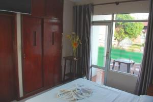 a bedroom with a bed and a large window at Hostal Ibiza in Santa Cruz de la Sierra