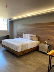 a bedroom with a large bed and a wooden headboard at ZEGEN HOTELS LagosdeMoreno in Lagos de Moreno +28 photos