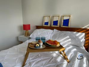 a tray of fruit and eggs on a bed at Harbord House - Ocean views, plunge pool, 2 bed, free-wi-fi, superb location in Freshwater