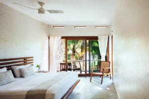 a bedroom with a large bed and a balcony at Olas Tulum in Tulum