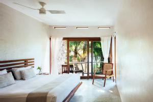 1 dormitorio con 1 cama grande y balcón en Olas Tulum en Tulum