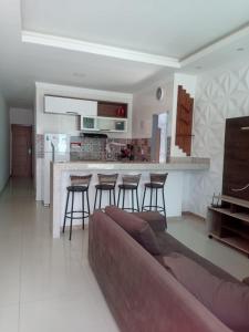 ein Wohnzimmer mit einem Sofa und einer Küche in der Unterkunft casa da paz in Porto Seguro