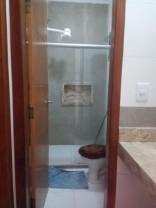 ein Bad mit einem WC und einer Glasdusche in der Unterkunft casa da paz in Porto Seguro