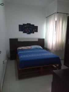 a bedroom with a bed with a blue blanket at casa da paz in Porto Seguro
