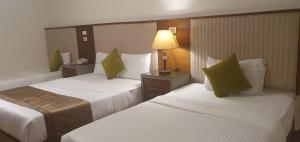 une chambre d'hôtel avec deux lits et une lampe dans l'établissement River Nile Edge Boutique Hotel & Restaurant, au Caire