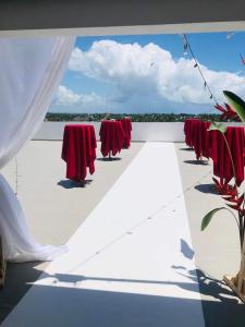 une rangée de tables et de chaises rouges sur un toit dans l'établissement Le Majestic Toamasina Hotel, à Toamasina