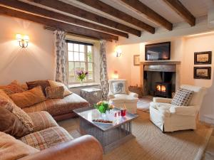 a living room with a couch and a fireplace at Warren Farmhouse in Kildale