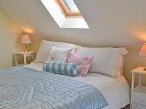 a bedroom with a bed with pillows and a window at A Bit On The Side in Chillenden
