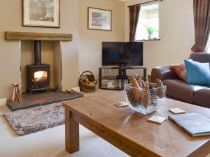 uma sala de estar com uma mesa de café em madeira e uma lareira em Newstead Cottage em Thornton Dale