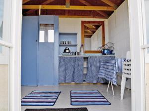 a kitchen with blue doors and a kitchen with mats on the floor at Sunrise Barn - E4865 in Chapel Saint Leonards