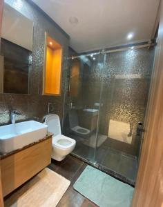 a bathroom with a shower and a toilet and a sink at New Luxury Apartment Sea View in Agadir