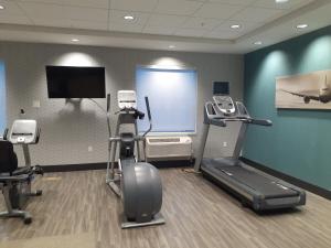 a gym with cardio equipment and a flat screen tv at Simple Suites Boise Airport in Boise