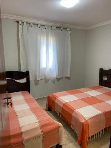 マイリポランにあるChácara em Alpes de Mairiporãの窓付きの客室で、ベッド2台が備わります。