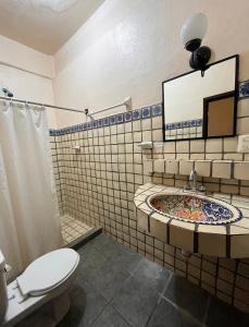 La salle de bains est pourvue d'un lavabo, de toilettes et d'une baignoire. dans l'établissement Hotel Rancho Escondito, à Puerto Escondido