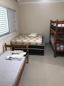 - une chambre avec 2 lits et des lits superposés dans l'établissement Sobrado para locação diaria a poucos metros do mar, à Guaratuba