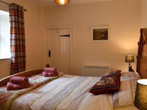 a bedroom with a bed with pink pillows on it at Coach House Cottage in Buckden