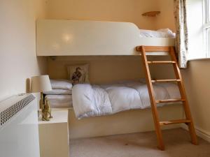 - un lit superposé avec une échelle dans une chambre dans l'établissement Coach House Cottage, à Buckden