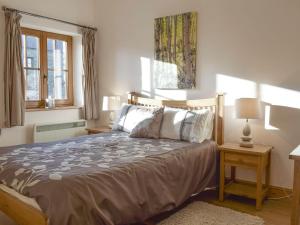 a bedroom with a bed and two lamps and windows at Gwel-y-lyn in Mydroilin