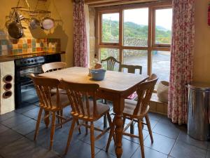 a kitchen with a wooden table and chairs and a window at Finkle Barn in Fryup