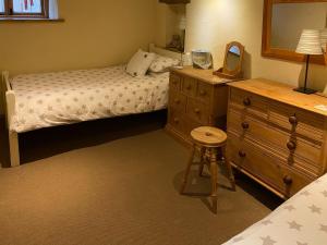 a bedroom with two beds and a dresser with a mirror at Finkle Barn in Fryup
