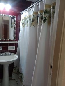 baño con cortina de ducha blanca y lavamanos en Hotel Neptuno en Miramar