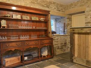 a living room with a fireplace and a wooden shelf at The Shooting Lodge in Saint Mabyn