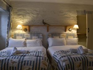 a bedroom with two beds and a bird on the wall at The Shooting Lodge in Saint Mabyn