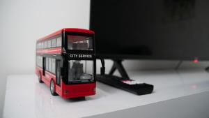 a red toy bus sitting next to a computer monitor at City service Apartment in Beeston