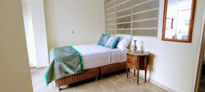 1 dormitorio con cama con espejo y mesa en Bienvenidos Hospedaje, en Medellín