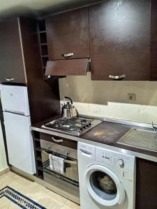 a kitchen with a stove and a washing machine at Apartments Babylone 2 Marrakech in Marrakesh