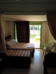 a bedroom with a bed and a couch and a window at Apartments Babylone 2 Marrakech in Marrakesh