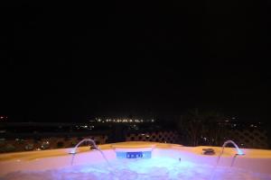 una bañera de hidromasaje por la noche con la ciudad al fondo en Empire Apartments Su 1 Celinastraat, en Paramaribo