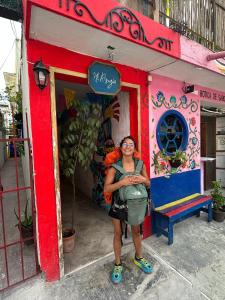 Una donna in piedi di fronte a un palazzo di Mi Refugio Dive House a Cozumel