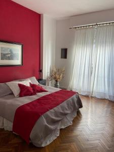 Un dormitorio con una pared roja y una cama grande en Departamento en Recoleta, Buenos Aires en Buenos Aires