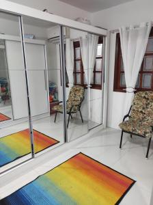 Habitación con 2 sillas y alfombra de arco iris. en Pousada da Dinda - Casa Familiar, en São Gabriel