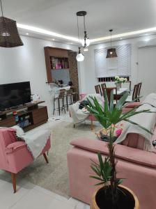 una sala de estar con muebles de color rosa y una maceta. en Pousada da Dinda - Casa Familiar, en São Gabriel