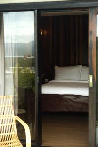 ein Schlafzimmer mit einem Bett, einem Stuhl und einem Fenster in der Unterkunft El Nido Bayview Resort in El Nido