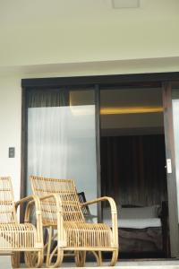 two wicker chairs sitting in front of a bedroom at El Nido Bayview Resort in El Nido