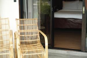 una silla de mimbre sentada frente a un dormitorio en El Nido Bayview Resort, en El Nido