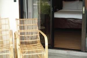 a wicker chair sitting in front of a bedroom at El Nido Bayview Resort in El Nido +120 photos