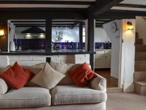 a living room with a couch and a kitchen at Merryweather Cottage in Bembridge