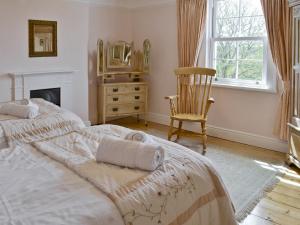 StrattonにあるTrew Houseのベッドルーム1室(ベッド1台、椅子、鏡付)