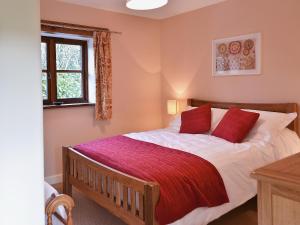 a bedroom with a large bed with red pillows at Jacks Barn - Hssu in Welcombe