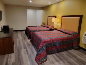 a hotel room with two beds and a television at Stadium Inn & Spas in Los Angeles