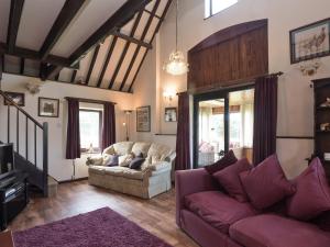 ein Wohnzimmer mit 2 Sofas und einem lila Teppich in der Unterkunft Sky Lark in Weybourne