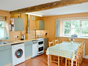 a kitchen with a table and a table and chairs at The Stable-e2836 in Whitminster