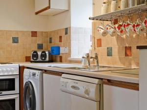 cocina con fregadero y lavavajillas en Rams Cottage en Glenelg