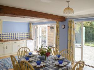 a dining room with a table and chairs and a kitchen at Fiddledrill Barn in Benniworth