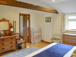 Schlafzimmer mit einem Bett, einer Kommode und einem Spiegel in der Unterkunft Fiddledrill Barn in Benniworth