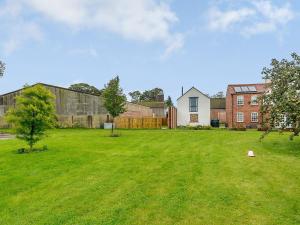 a large green yard with a house in the background at Westfield Stables in Green Hammerton